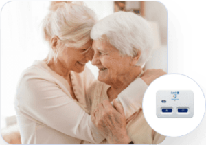 An elderly woman hugging her elderly mother smiling