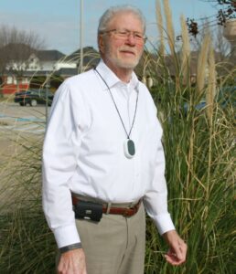 A remote patient monitoring pendant on senior man in white shirt